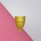 Golden silicone menstrual cup isolated on background. Means of female hygiene. 3d rendered