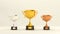 Golden, silver and bronze cup, trophy or winner prize on wooden pedestal for championship. Award for first second third