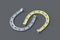 Golden and silver horseshoes on a gray background. Symbol of luck. Successful concept