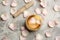 Golden singing bowl with petals and mallet on grey table, flat lay. Sound healing