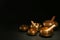 Golden singing bowls with mallets on black table against dark background, space for text
