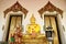 Golden Sitting Posture Buddha Image with a Standing Posture One in Buddhist Temple in Thailand