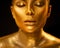 Golden skin woman face. Fashion art portrait closeup. Model girl with holiday golden glamour shiny professional makeup