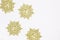 Golden snow flakes with glittering white background. Christmas theme.