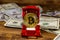 Golden souvenir coin bitcoin in car-shaped gift box for jewelry and dollars on wooden background