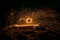 Golden sparks spray at night at stones rocks puddle reflects the sparks through glowing steel wool which is flung in a circle, Ger