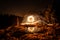 Golden sparks spray at night at stones rocks puddle reflects the sparks through glowing steel wool which is flung in a circle, Ger