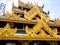 The golden square hall with a pyramidal roof castle mondop and golden tiered umbrella under the blue sky