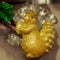 Golden squirrel hanging as decoration on a green Christmas tree, close-up