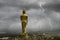 Golden standing Buddha image and lightning storm over the town