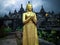 Golden Standing Buddha Statue In Front Of Buddhist Temple At Buddhist Monastery