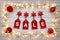 Golden star christmas lights, and red baubles, on a destressed wooden background, creating a border around hanging tags spelling