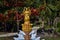 Golden statue of the goddess in the blooming garden Buddhist temple at a small Thai village