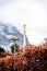 Golden statue on tip of church spire against snowy mountain and cloudy sky views