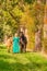 In the golden sun a portrait of a blond smiling girl with her horse and foal in the forest. Wearing a green dress. Selective focus