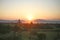 The golden sun sinks towards the Irrawaddy River and the distant mountains in Myanmar