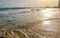 Golden sunlight reflecting on a beach in Lagos, Nigeria. Sun shining in the evening - waves breaking on the shore