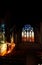 Golden sunlight through a stained glass window falling on the wall inside a church