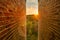 Golden Sunrise and Landscape Between Brick Walls