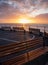 Golden sunrise over a line of benches looking out to sea. copy space.