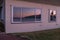 A golden sunset on a beach on Waiheke Island, New Zealand, a near perfect reflection of the sunset in the window of a nearby home