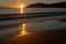 A golden sunset on a beach on Waiheke Island, New Zealand, Thailand, the colour of the sun reflecting on the wet sand