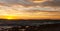 Golden sunset behind Conejera Islands. Choppy waters of Balearic sea churns waves on rocks along shore. View of Conejera Island