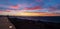 Golden sunset behind Conejera Islands. Choppy waters of Balearic sea churns waves on rocks along shore. View of Conejera Island