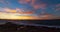 Golden sunset behind Conejera Islands. Choppy waters of Balearic sea churns waves on rocks along shore. View of Conejera Island