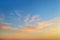 Golden sunset clouds in a clear blue sky. Scenic dusk skyscape. Twilight paradise sky. Calm heaven background