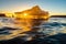 golden sunset highlighting iceberg surfaces in open ocean