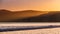 Golden sunset light illuminating the shoreline of the Pacific Ocean, Drakes Beach, Point Reyes National Seashore, California