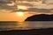 Golden sunset over the Mediterranean Sea. The setting sun shines through the clouds, and a golden path is visible above the ocean