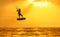 Golden sunset over the sea with the men kiting silhouette