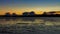 A golden sunset reflecting over the mudflats of Kirkcudbright Bay in winter