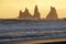 Golden sunset at Reynisdrangar cliffs on Black sand beach in Vik, Iceland