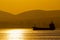 Golden sunset, silhouette of the city and cargo ship. Beautiful architecort by the sea on the background of the sunset