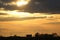 Golden sunset sky with silhouettes trees, house