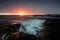 Golden sunset sky stretches across the horizon, illuminating the ocean. Norway, Atlantic Ocean Road.