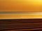 Golden sunset or sunrise on racked beach panorama.