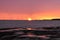 Golden sunset, turbines and rocky shore