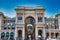 The golden sunshine is reflecting on the front of the magnificent triumphal arch entrance of the Galleria Vittorio Emanuele II