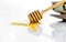 Golden sweet honey with a wooden honey dipper on the white ceramic background.