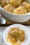 Golden Syrup Dumplings on Table with One portion on Plate Vertical