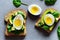 Golden toast with avocado and chicken egg and basil leaves