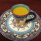 Golden turmeric latte in Spanish ceramic coffee cup and plate