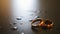 Golden wedding rings on table with drops of water, rack focus