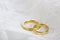 Golden wedding rings on white lace