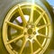Golden wheel rim of a car on a bright sunny day