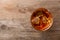 Golden whiskey in glass with ice cubes on wooden table, top view.